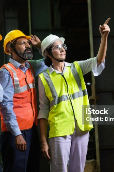 Team of  indian engineers wearing safety hard hat and vest doing supervision  at industrial factory, male and female professional workers working, skill india concept.